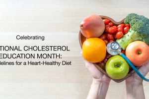 Hands holding a heart-shaped bowl filled with fruits and vegetables, such as apples, oranges, tomatoes, and broccoli, with a stethoscope draped over the bowl; text promotes National Cholesterol Education Month and heart-healthy diet guidelines.