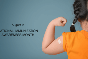 A young girl in an orange shirt shows her arm with a bandage, symbolizing vaccination. Text reads August is NATIONAL IMMUNIZATION AWARENESS MONTH on a blue background.