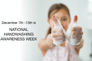 A child with soapy hands gives two thumbs up. Text beside her reads, December 7th - 13th is NATIONAL HANDWASHING AWARENESS WEEK. The background is a bright, clean room.