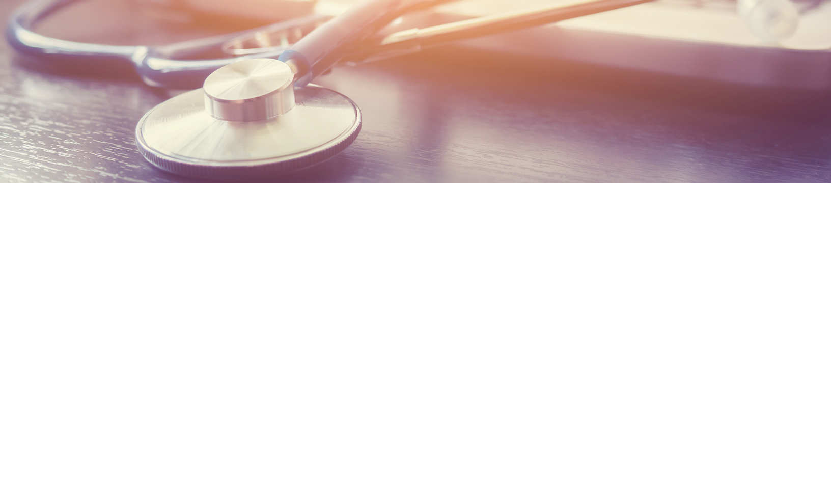 A close-up of a stethoscope lying on a dark wooden surface, with soft sunlight shining across the image, creating a warm and calm atmosphere.